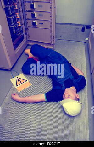 electrician electrocuted - wounded man lying on the ground Stock Photo