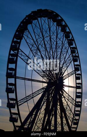 Ferris wheel silhouette against dark blue sky Stock Photo