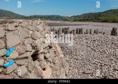 World War Two Pill Box concrete bunker with lost colorful beach sandals wedged into the stone work. Porlock Weir, Exmoor England Stock Photo