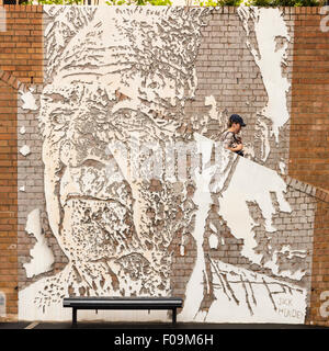 Man descends staircase on Globe St within the Alexandre Farto mural of Jack Mundey in The Rocks, Sydney Stock Photo