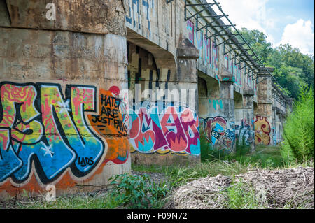 Graffiti covered supports on an old bridge in Asheville, North Carolina's River Arts District. USA. Stock Photo