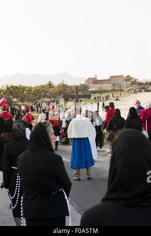 Priest holding cross and women walking in procession at Nora, Cagliari, Sardinia, Italy Stock Photo