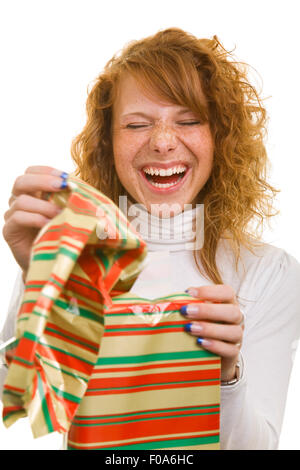 Young happy redhaired woman opening a christmas gift Stock Photo