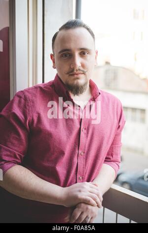 Portrait of young man by window Stock Photo