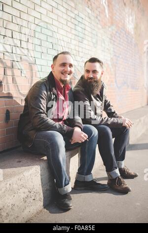 Gay couple sitting on concrete bench Stock Photo