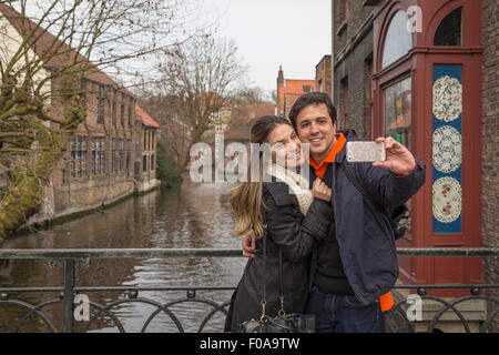 Couple taking smartphone selfie, Bruges, Flanders, Belgium Stock Photo