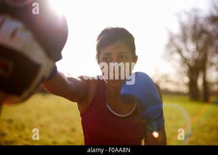 Mature female boxer training in field Stock Photo