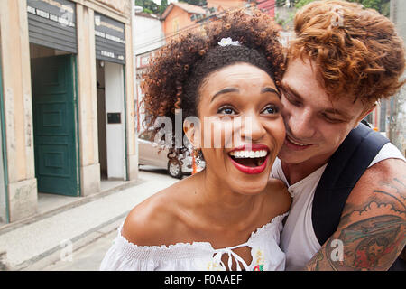 Young couple fooling around in street, laughing, close-up
