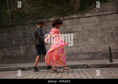 Couple walking along cobbled street, rear view Stock Photo