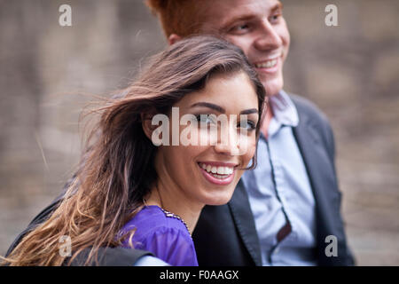 Young couple standing together, outdoors, looking away, smiling Stock Photo