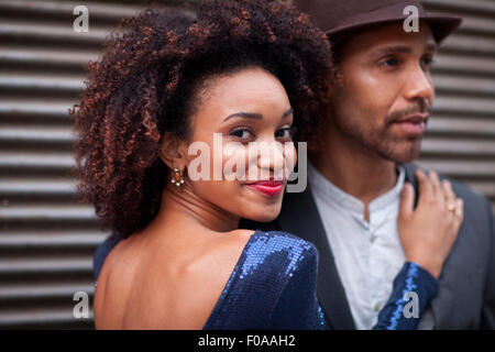 Couple standing outdoors, hugging, looking at camera, smiling Stock Photo