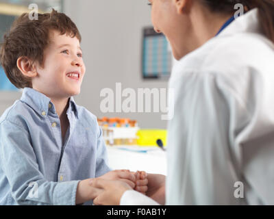 Doctor comforting young boy in clinic Stock Photo