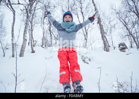 Boy jumping down snow covered hill, Hemavan,Sweden Stock Photo