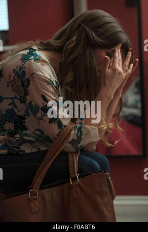 Woman holding head in hands Stock Photo