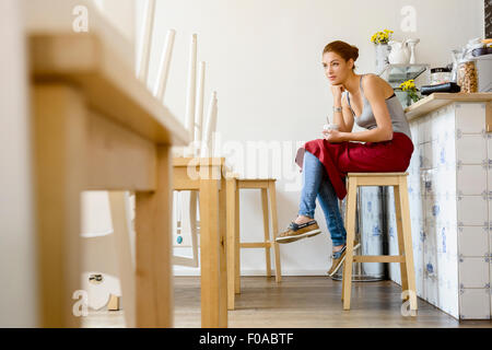 Waitress in cafe sitting on stool Stock Photo