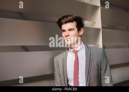 Young city businessman walking outside office Stock Photo