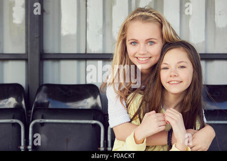 Portrait of two smiling girls hugging in stadium stand Stock Photo - Alamy