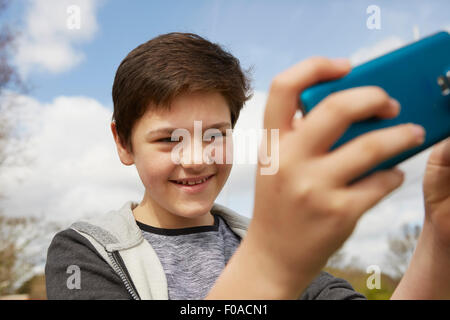 Smiling teenage boy taking smartphone selfie Stock Photo