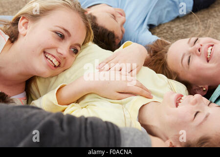 Five boys and girls lying on path laughing Stock Photo