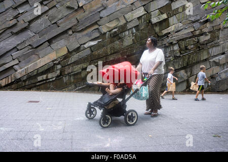 A nanny pushing a pram in Manhattan's Teardrop Park, designed by landscape architect, Michael Van Valkenburgh. Stock Photo