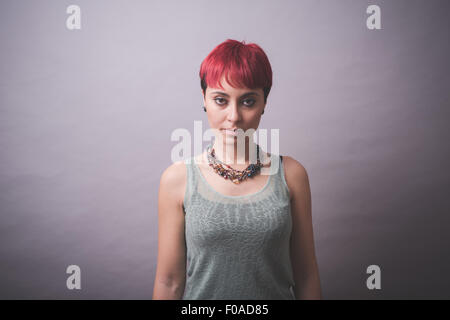 Studio portrait of young woman with short pink hair Stock Photo