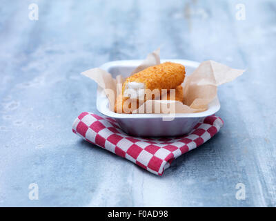 Fried chunky breaded cod fish fingers in baking tin on steel table Stock Photo