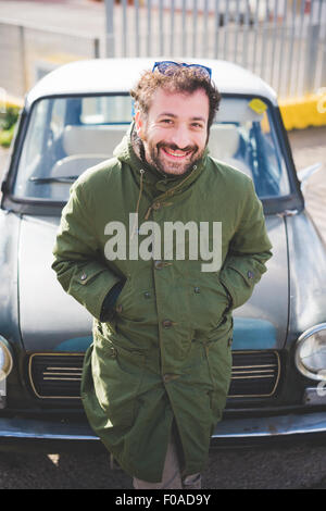 Portrait of mid adult man leaning on vintage car Stock Photo