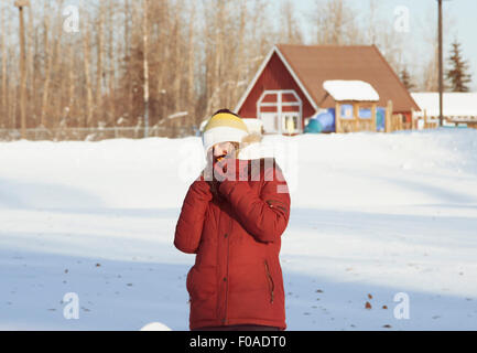 Young woman wearing winter coat in snow Stock Photo