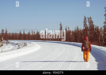 Person walking on snow covered road, Fairbanks, Alaska Stock Photo