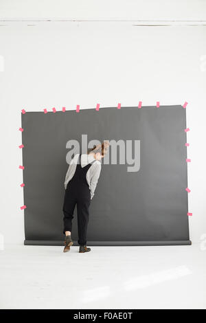 Woman in front of photographers backdrop, rear view Stock Photo