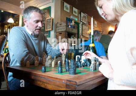 Couple playing chess in pub Stock Photo