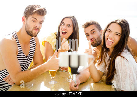 Group of friends at the beach bar and making a selfie Stock Photo