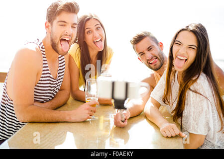 Group of friends at the beach bar and making a selfie Stock Photo