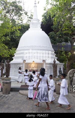 Children and woman at Gangaramya temple during Navam Perahera, Colombo, Sri Lanka Stock Photo