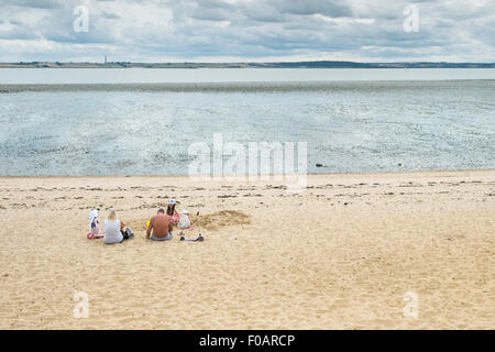 Canvey island - A family relaxing on the beach at Thorney Bay on Canvey Island, Essex. Stock Photo