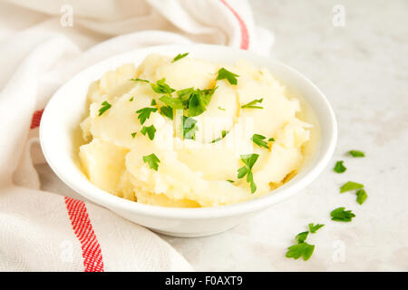 Mashed potatoes with parsley in white bowl Stock Photo