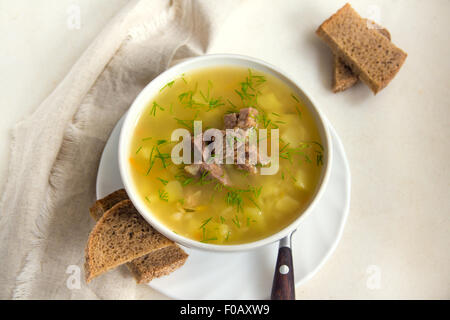 Fresh pea soup with meat in white bowl Stock Photo
