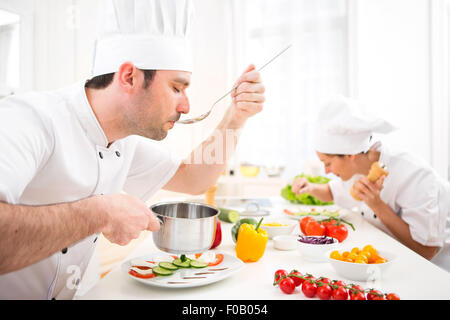 View of a Young attractive professional chef tasting sauce Stock Photo