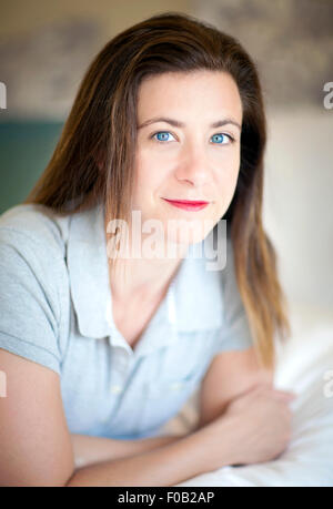 Pretty brunette woman lying on a bed Stock Photo