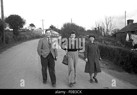 A man and two women walking down a road in England. Stock Photo