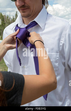 Dillon, Colorado - A groomsman gets help from a woman in tying his necktie before a wedding. Stock Photo