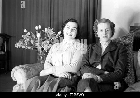 Two middle aged women sitting on a sofa. Stock Photo