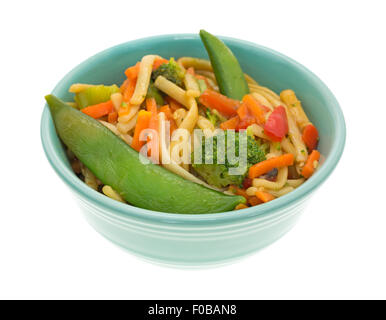A small green bowl with a serving of sesame seasoned noodles with assorted vegetables isolated on a white background. Stock Photo