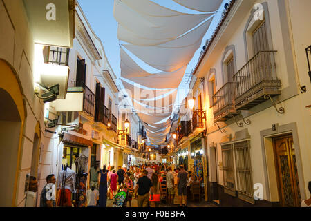 Tourists in Street in Andalusian white village of Nerja covered with Sun shade protection, Summer evening, Malaga, Spain. Stock Photo
