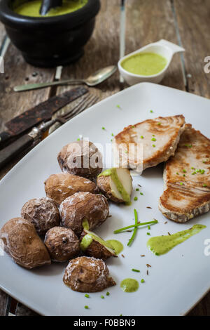 tuna steak with pesto sauce served with potatoes Stock Photo