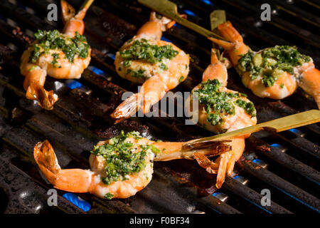 Shrimp skewers coated with herbs and garlic butter on the barbecue grill Stock Photo