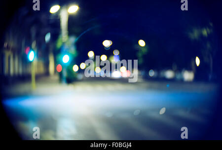 Blurred street at night time. Vintage looking shot made with old lens Stock Photo