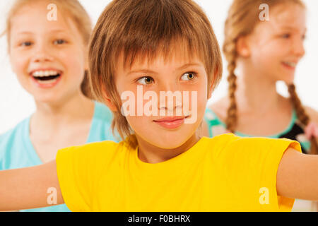 Portrait of cute boy with two girls on background Stock Photo