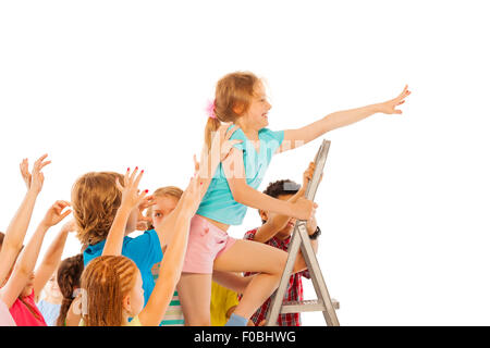 Best in class girl climb up other pull down Stock Photo