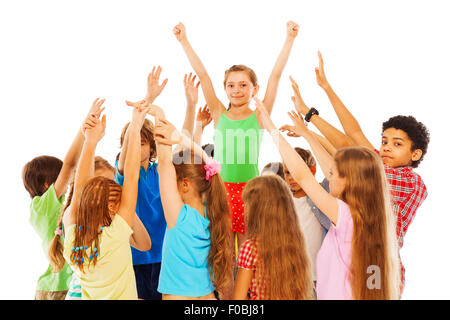 Happy girl with raised hands in group of kids Stock Photo